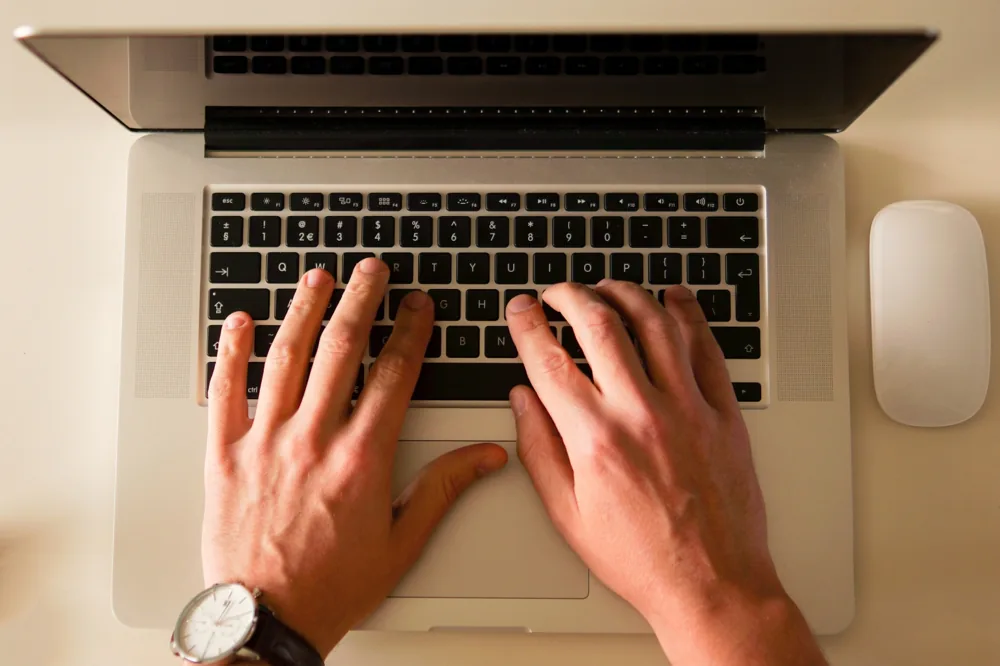 A person working on a laptop at a desk